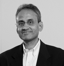 A man in a suit and tie smiling for the camera.