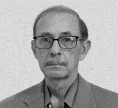 A man with glasses and a suit on.