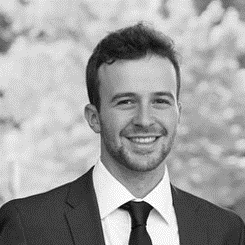 A man in suit and tie smiling for the camera.